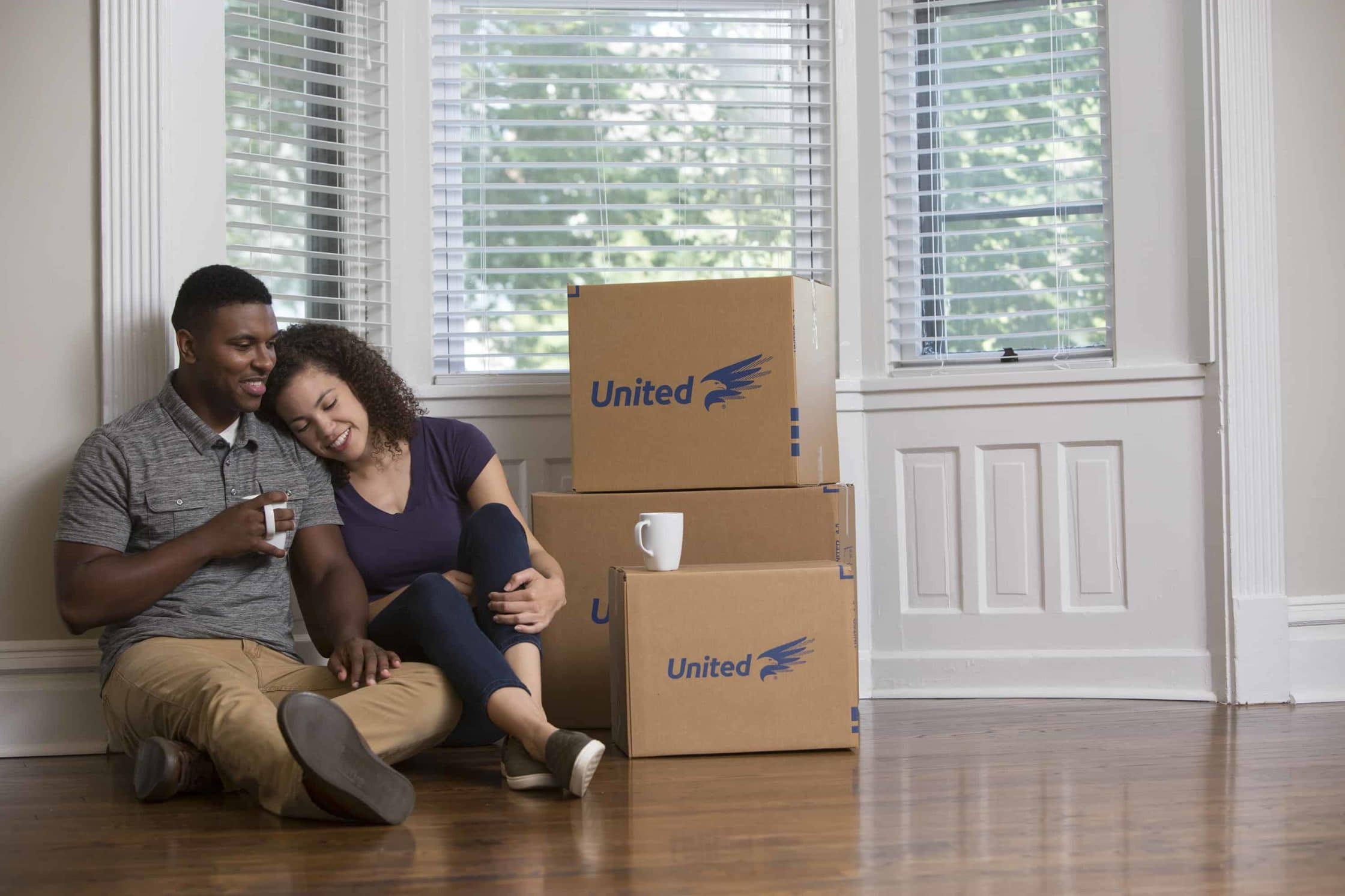 First Night Moving Box Checklist - couple sitting next to moving boxes - United Van Lines