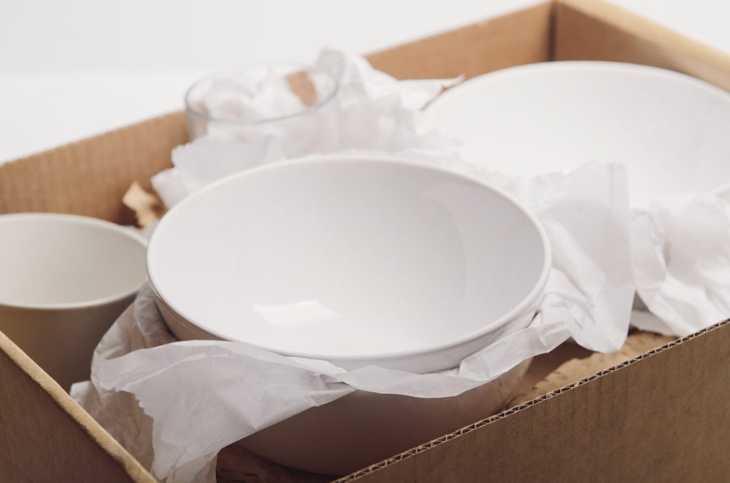 Moving box packed with dishes and padding as part of moving supplies checklist article
